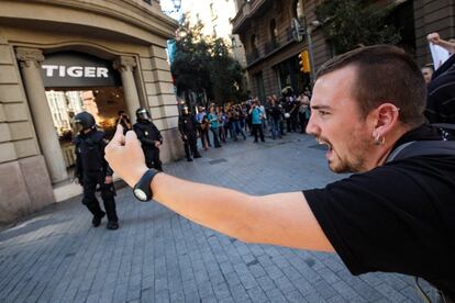 Un manifestante grita consignas a un grupo de agentes de la Policía Nacional durante la huelga estudiantil en Barcelona.  