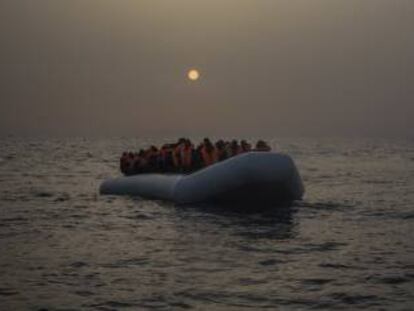 Varios refrugiados y migrantes esperan, abordo de un un bote de goma a la deriva, a ser asistidos por miembros de la ONG española Proactiva Open Arms.