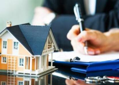 Una persona firmando la compra de una casa