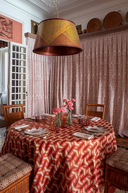La mesa del comedor está vestida con un mantel diseñado por David Hicks para Cabana. La lámpara colgante de cobre pintado es de Renzo Mongiardino; las sillas son de la firma Bonacina, y las cortinas, un diseño de Ashley Hicks.
