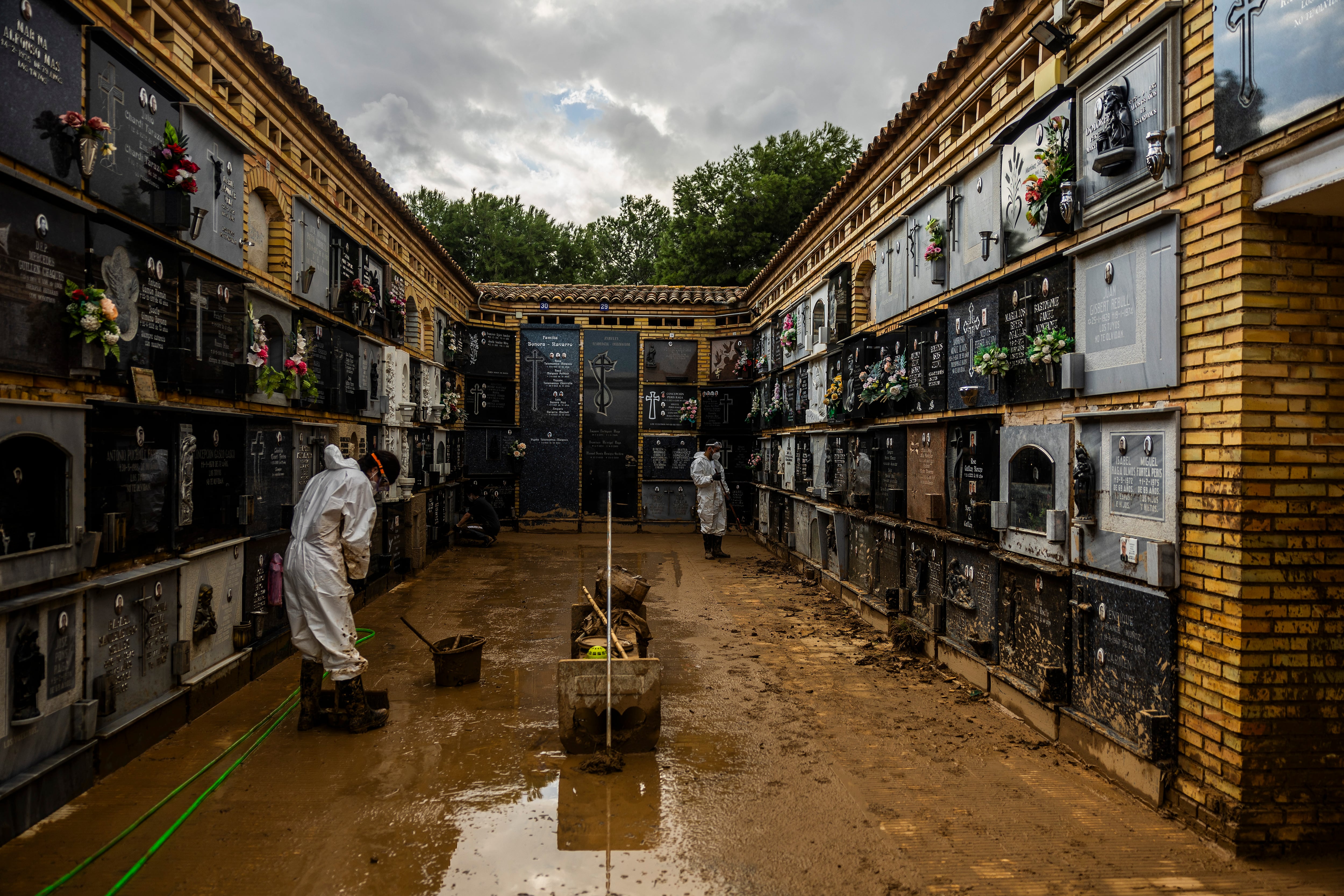 Dos voluntarios trabajan en el cementerio de Catarroja tras los daños causados por la dana.
