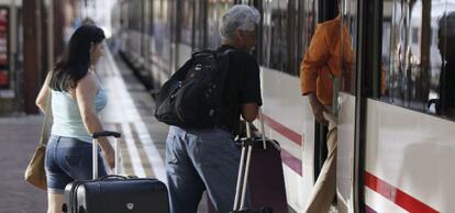 Varias personas montan a un tren en la estaci&oacute;n de Chamart&iacute;n, en Madrid. 