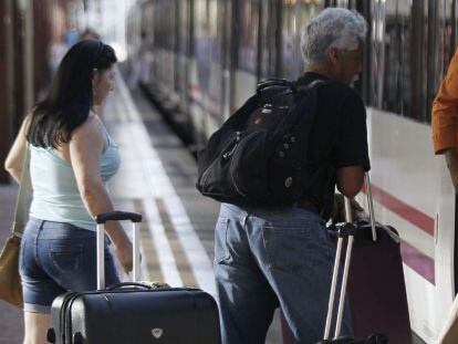 Varias personas montan a un tren en la estaci&oacute;n de Chamart&iacute;n, en Madrid. 