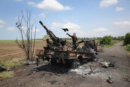 Un vecino de Dmytrivka limpia un vehículo militar ucranio quemado en una emboscada de separatistas prorrusos.