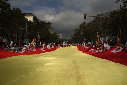 Una enorme bandera de España es llevada por los manifestantes.
