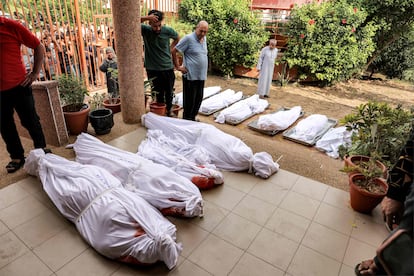 Varias personas se reúnen en el patio de un depósito de cadáveres junto a los cuerpos de los palestinos muertos, tras un ataque israelí en Jan Yunis (Gaza).
