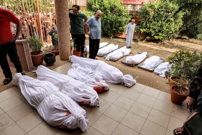 Varias personas se reúnen en el patio de un depósito de cadáveres junto a los cuerpos de los palestinos muertos, tras un ataque israelí en Jan Yunis (Gaza).