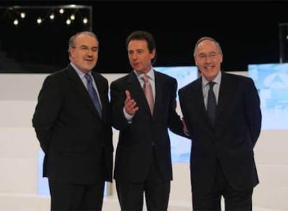 Pedro Solbes (izquierda) y  Manuel Pizarro (derecha) posan junto al moderador del debate, Matías Prats.