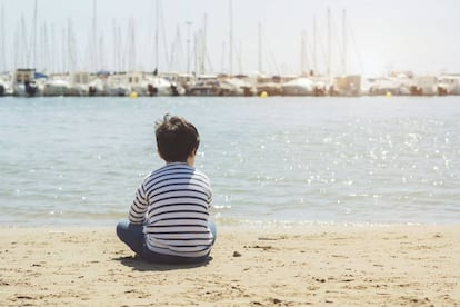 Un niño mira al horizonte.
