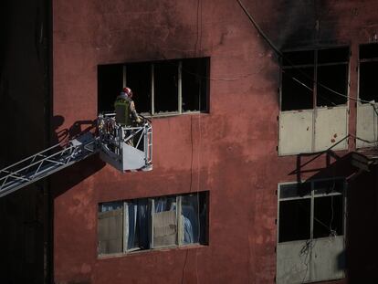 Bomberos trabajan en los exteriores de la nave incediada en Badalona.