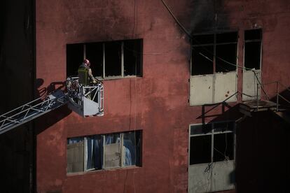 Bomberos trabajan en los exteriores de la nave incediada en Badalona.