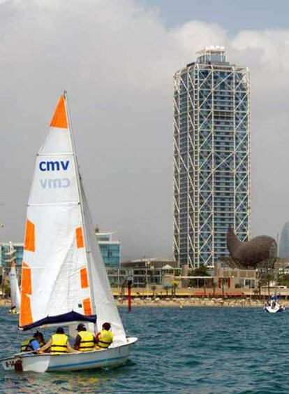 Un velero navega en aguas cercanas a la torre del Hotel Arts.