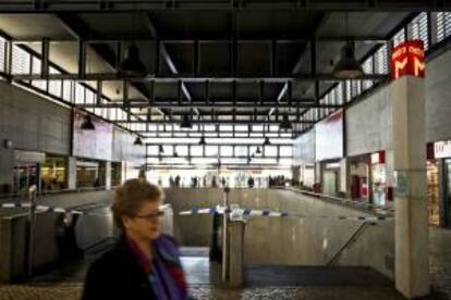 Una mujer pasa delante del acceso cerrado de la estación de metro Cais do Sodre durante una huelga de 24 horas de los trabajadores de metro en contra de los recortes previstos para el sector en los Presupuestos Generales del Estado de 2014 hoy en Lisboa (Portugal).