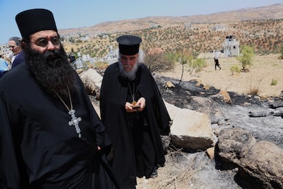 Dos religiosos, este lunes, ante la zona calcinada por colonos judíos junto a la Iglesia de San Jorge de Taybeh (Cisjordania).