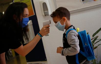 Una profesora toma la temperatura a un alumno en la Escuela Mare de Deu de Monserrat, en Terrassa (Barcelona).