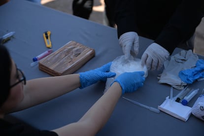 Personas realizan pruebas químicas a sustancias para verificar que se trate de metanfetamina, en Hermosillo (Sonora), en octubre de 2021. 