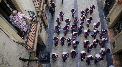 Una vecina de la parte vieja observa el paso de las compañías por las calles de San Sebastián.