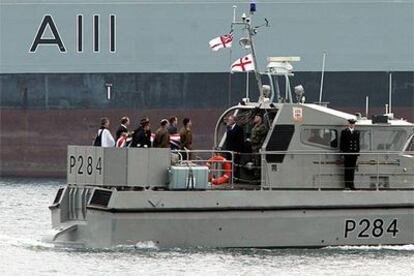 El féretro con el cadáver de David White, cubierto con la bandera británica, es transportado por un barco de la Marina en el puerto de Gibraltar.
