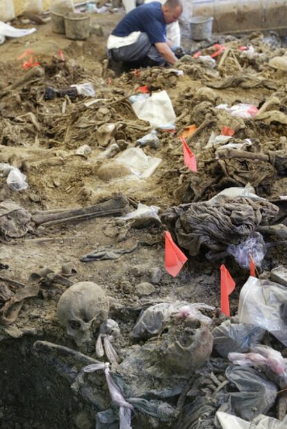 Un forense examina los restos hallados en una fosa común en la ciudad de Kamenica.