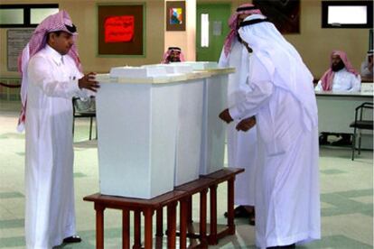 En la imagen, varios hombre preparan las urnas de votación en Jobar.