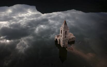 Una iglesia y restos de un antiguo pueblo que generalmente están cubiertos por agua se ven dentro del embalse de Sau, en Vilanova de Sau, Cataluña (España).