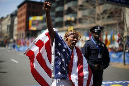 Meb Keflezighi de Estados Unidos con la corona de laurel y la bandera americana tras proclamarse vencedor de la 118 edición del maratón de Boston.