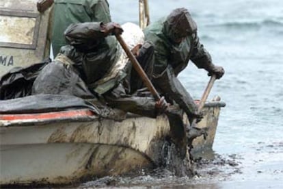 Dos voluntarios recogen fuel en las islas Cíes (Vigo).