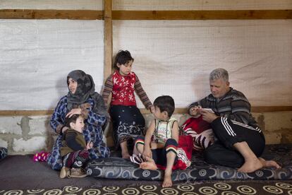 Los padres, los hermanos y la hermana de Shahd. La madre habla con una vecina que ha pasado a visitarla, otra refugiada que vive en la tienda contigua en un campamento improvisado en el Valle de la Bekaa (Líbano).