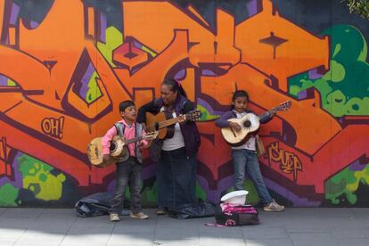 Una se&ntilde;ora con dos menores de edad cantan en las calles de la Ciudad de M&eacute;xico.