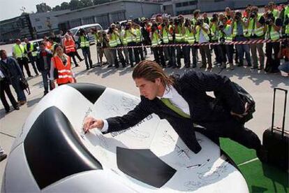 Sergio Ramos firma en un balón de Kamen a su llegada a la concentración de España en Alemania.