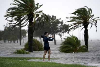 Um homem toma fotos na borda do lago Pontchartrain antes da proximidade do furacão Ida em Nova Orleans, no domingo 29 de agosto de 2021.