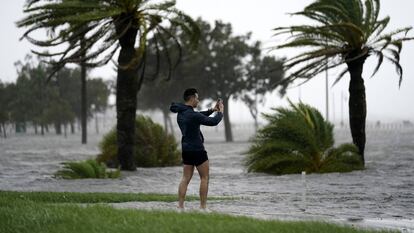 Um homem toma fotos na borda do lago Pontchartrain antes da proximidade do furacão Ida em Nova Orleans, no domingo 29 de agosto de 2021.