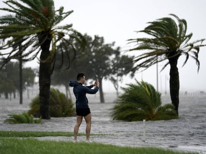 Um homem toma fotos na borda do lago Pontchartrain antes da proximidade do furacão Ida em Nova Orleans, no domingo 29 de agosto de 2021.