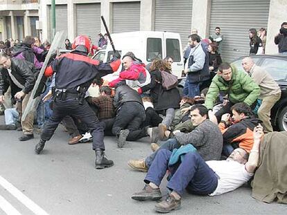 Agentes de la Ertzaintza cargan contra la manifestación, que finalmente llegó a Portugalete.