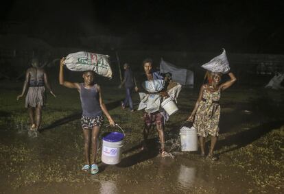 Una niña camina junto a su familia bajo la lluvia de la tormenta 'Grace' a su paso por Los Cayos, el pasado lunes 16.