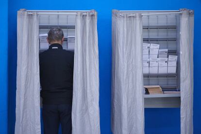 Una persona elige su papeleta para las elecciones generales, en un colegio de Pamplona.
