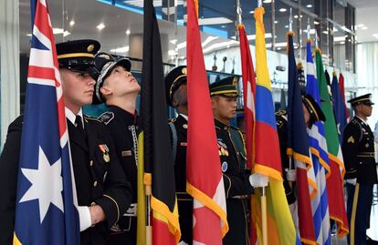 Guardias de honor de las Naciones Unidas sostienen varias banderas durante la ceremonia de conmemoración de los 64 años del fin de la Guerra de Corea, en Panmunjom, la zona desmilitarizada que divide a las dos Coreas.