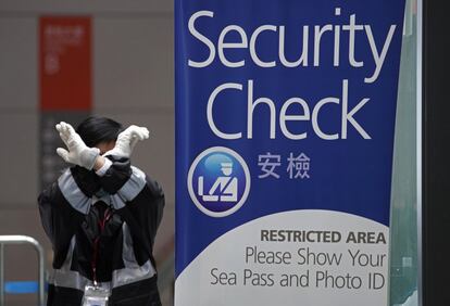 Un guardia de seguridad hace un gesto en la terminal de cruceros de Kai Tak Por el momento, 3 pasajeros han dado positivo en las pruebas del coronavirus en el crucero 'World Dream', paralizado en ese sector del puerto de Hong Kong con 1.800 personas dentro.