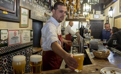 Un camarero sirve cervezas en un bar de Sevilla.