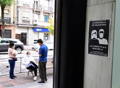 Residents in the Madrid district of Puente de Vallecas. The sign reads: “Face masks mandatory.”