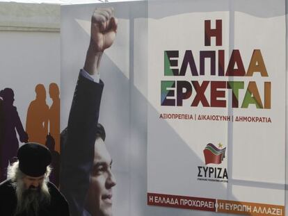 Un sacerdote ortodoxo camina delante de una caseta del principal partido de la oposici&oacute;n, el izquierdista Syriza, en el centro de Atenas, Grecia.