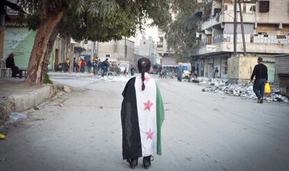 Una niña pasea envuelta en la bandera siria por Alepo, este miércoles.