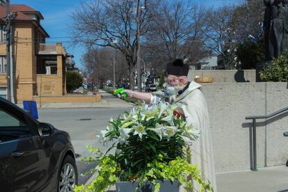 El sacerdote Timothy Pelc disparando agua bendita al coche de un feligrés en Míchigan.