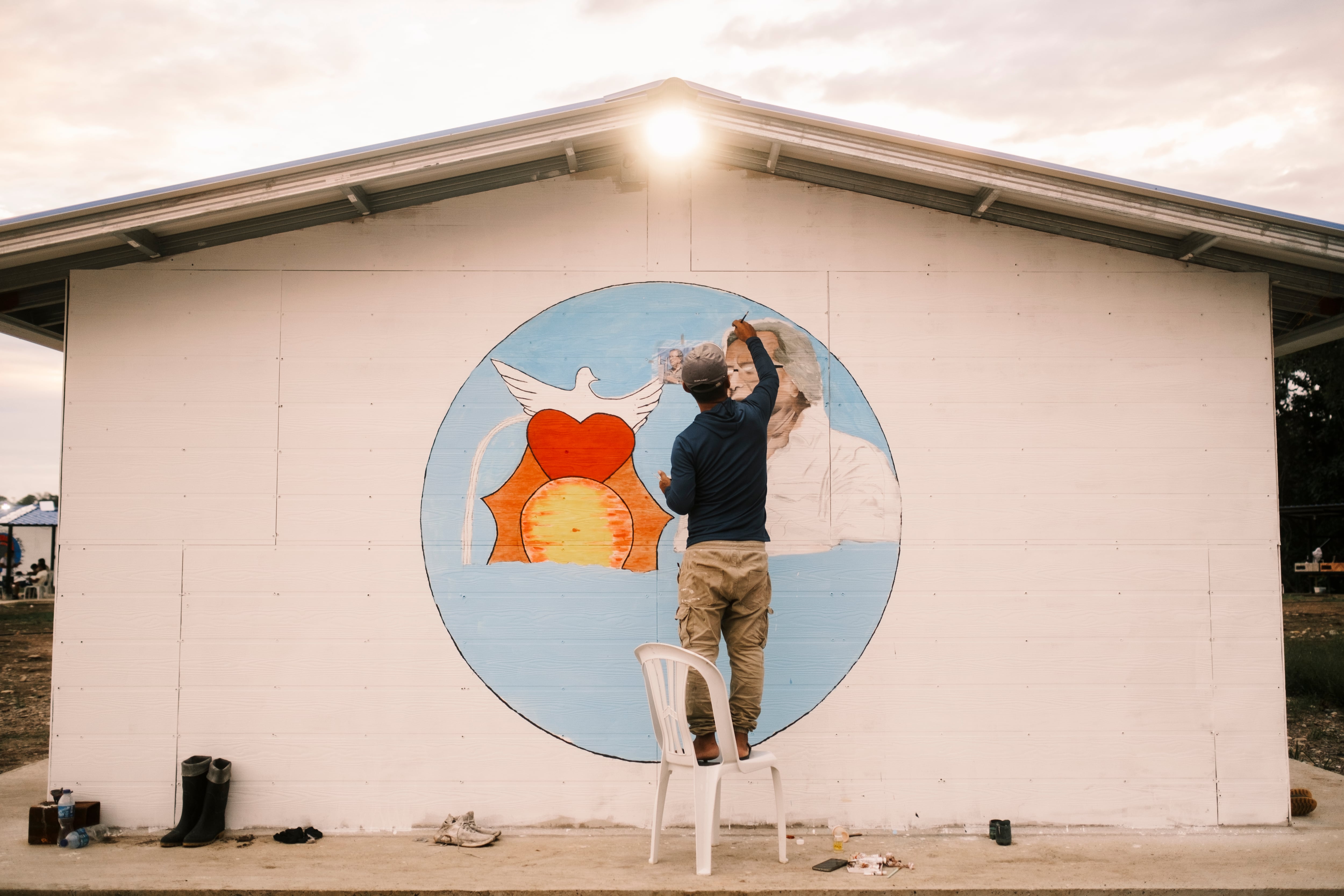 Un hombre pinta un mural en una de las viviendas de la Zona de Ubicación Temporal, en Putumayo, el 29 de julio.