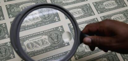 Inspección de billetes de dólar.