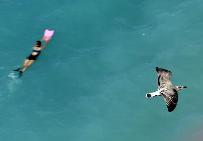 Una mujer nada en las aguas turquesas del Mediterráneo en Niza, Francia.