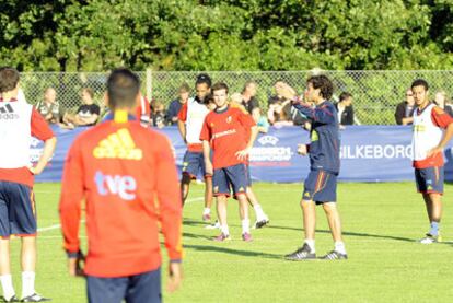 Mata (en el centro) escucha con sus compañeros las instrucciones de Luis Milla, el técnico.