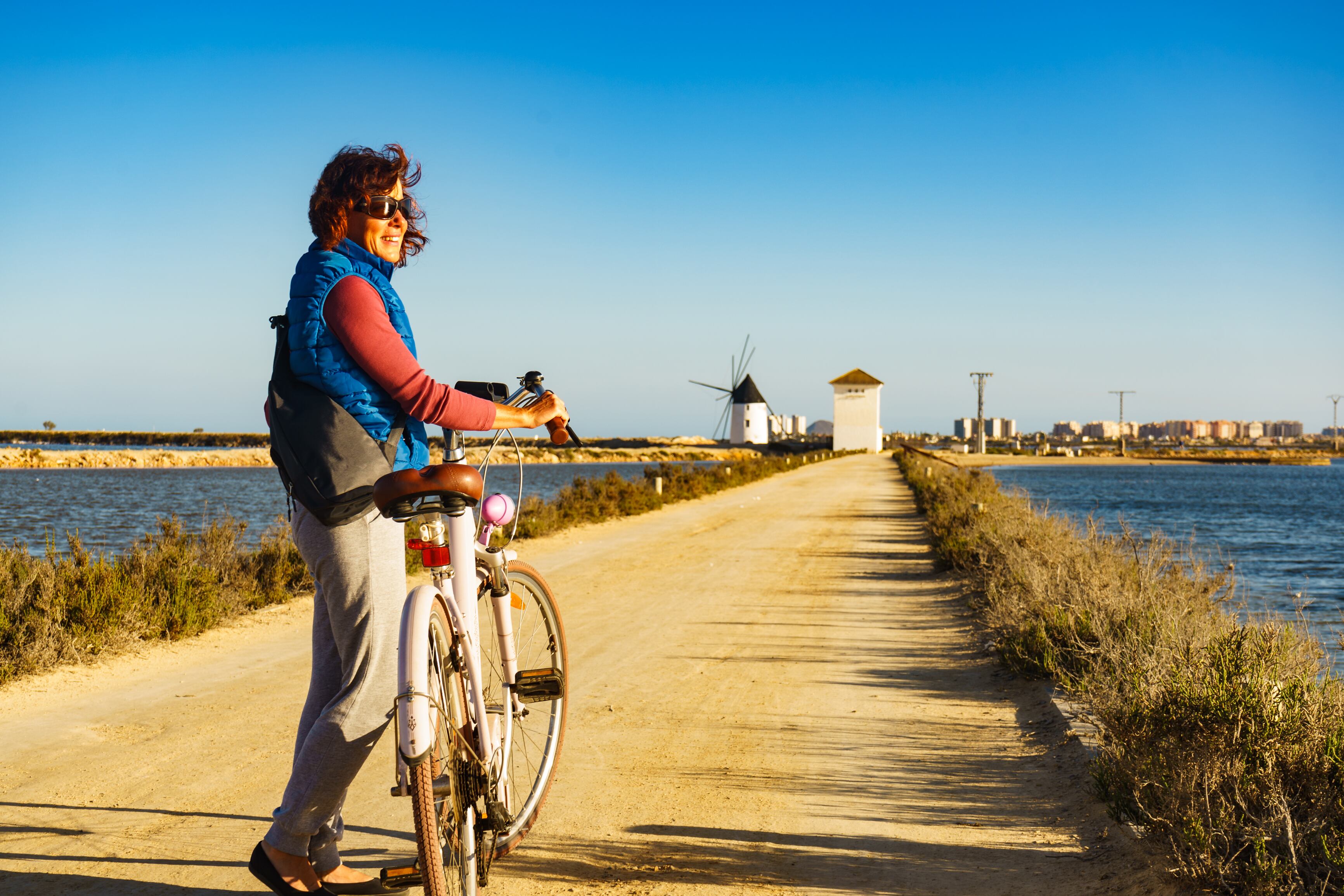 Una mujer recorre en bici el parque regional de las Salinas y Arenales de San Pedro del Pinatar.