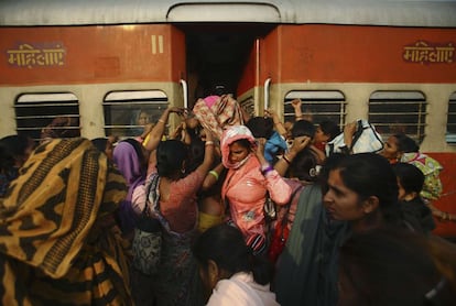 Un grupo de mujeres tratan de entrar en un vagon de damas del tren que se dirige hacia Delhi en la Estación Noli en Pradesh