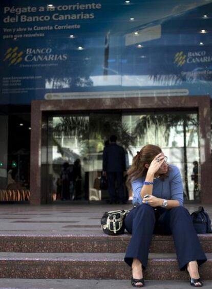 Una trabajadora ante una oficina en Caracas del Banco Canarias, una de las cuatro entidades intervenidas por las autoridades venezolanas.